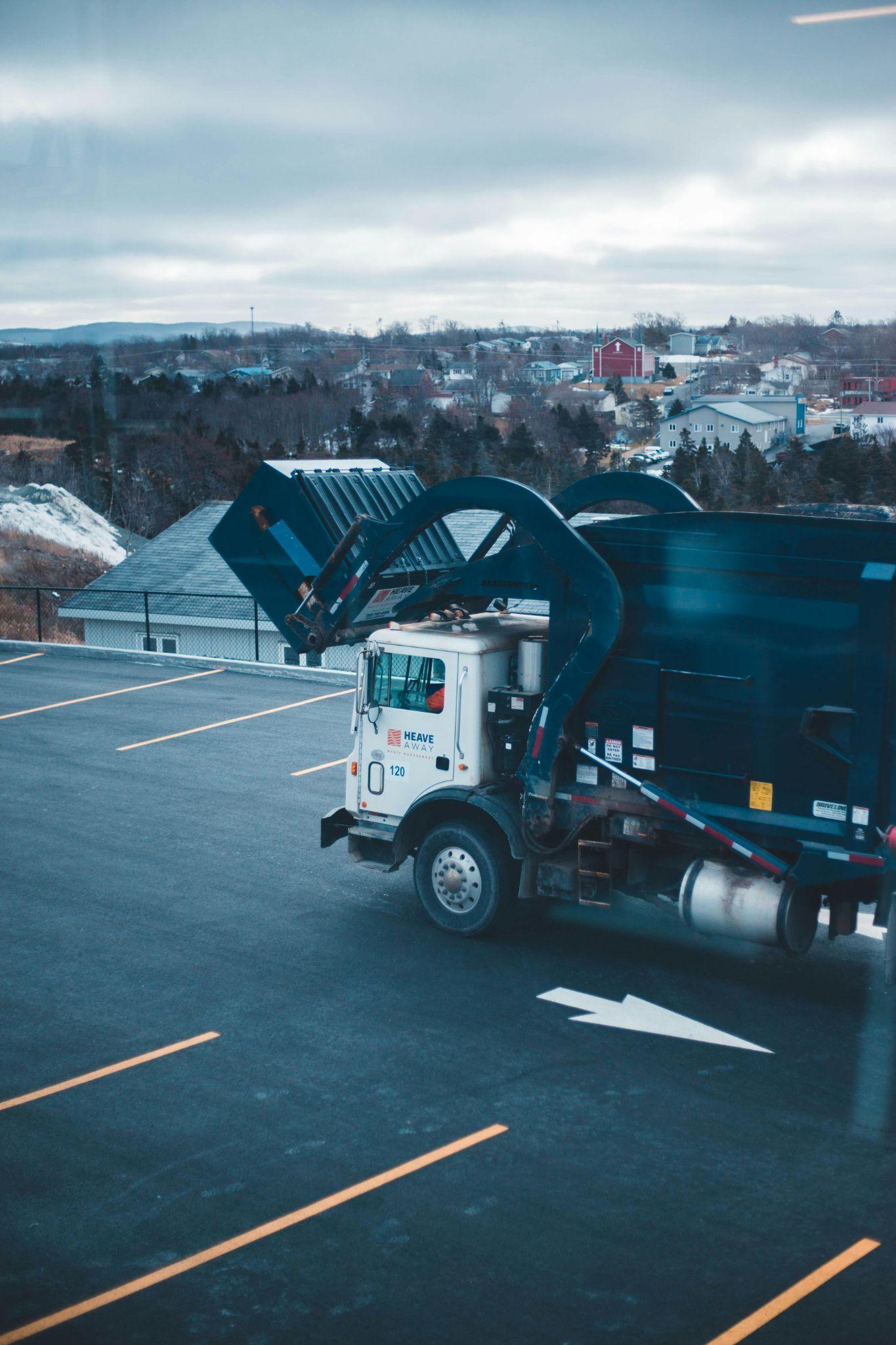 A waste-collection truck unloading at a transfer station